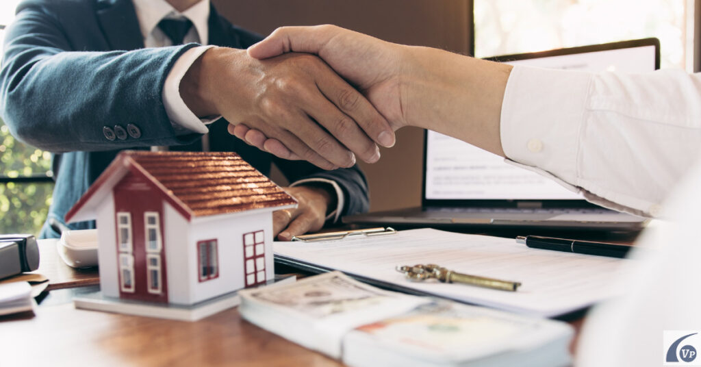 Dos personas estrechando la mano tras la venta de un piso con ayuda de una agencia inmobiliaria